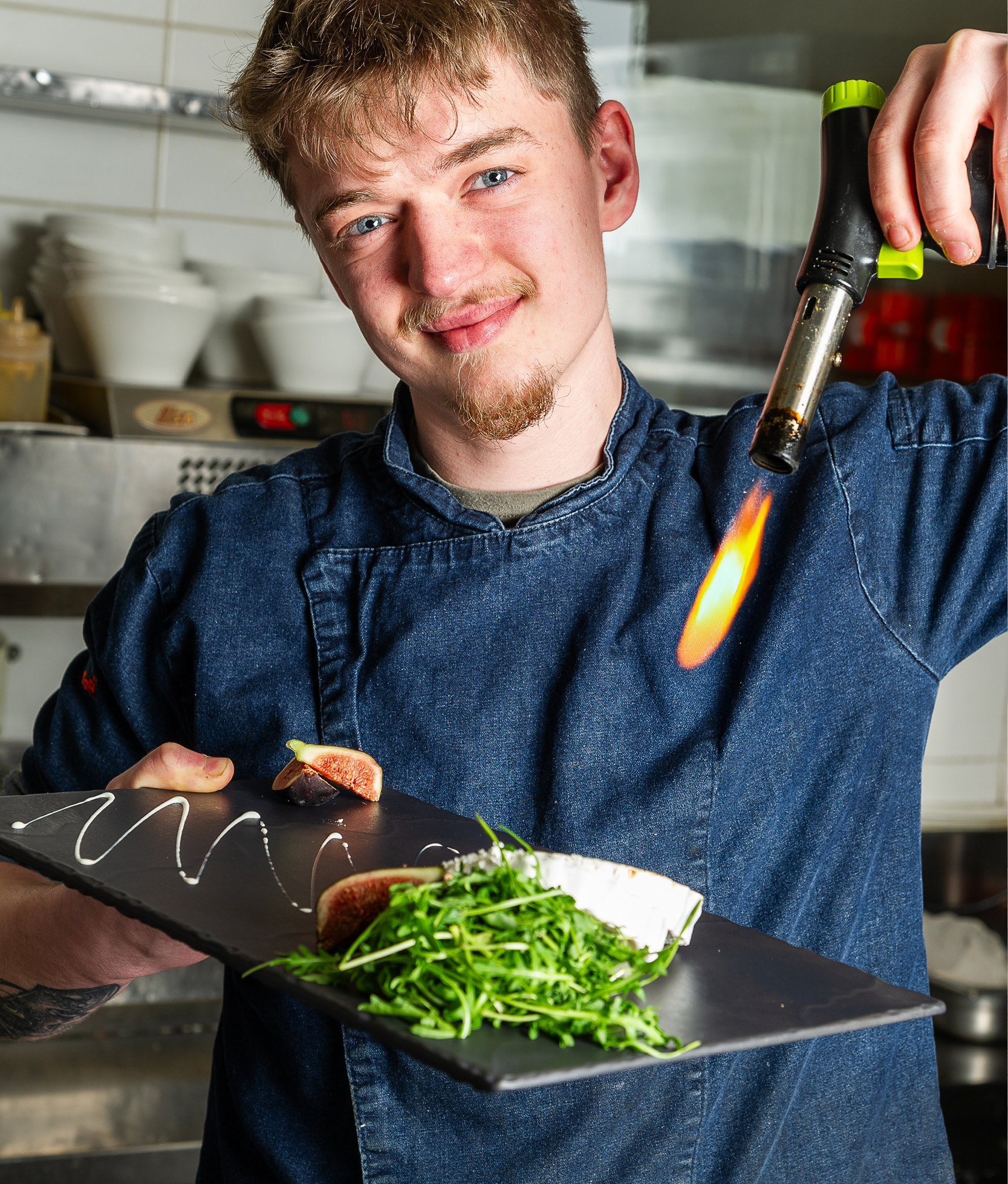 Koch beim flambieren einer Speise